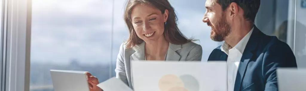 two business people during work meeting in modern office explaining statistics data to each other